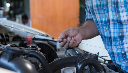 Obraz premium Car mechanic holding checking gear oil to maintenance vehicle by customer claim order in auto repair shop garage. Engine repair service. 