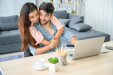 Happy and relax  lifestyle of young couple lover wearing casual dress together working on laptop notebook computer in living room at home.