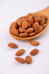 almonds and wooden spoon on white background