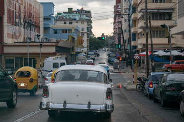 Nostalgic retro and modern imported cars clash in downtown Havana, Cuba.