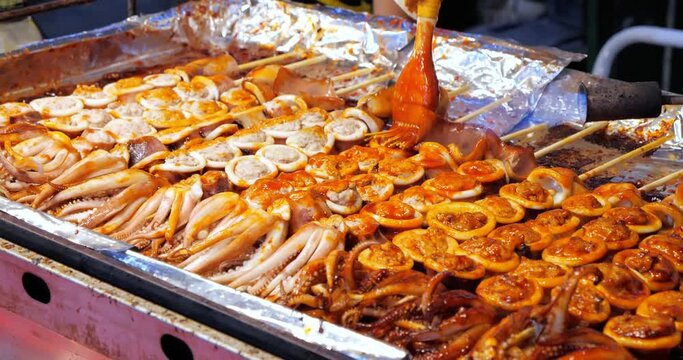 Spicy of Grilled squid satay with fire. Grilled squid on skewers, Delicious street food, Burning food, Blow torch cooking.