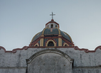 Fototapeta na wymiar Big old wall in Taxco Guerrero, church dome at the back