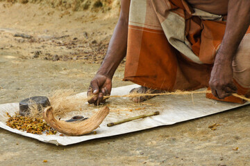 Man twisting coconut husk fiber (coir) into twine, Sri Lanka