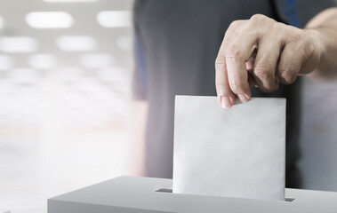 Hand holding ballot paper for election vote concept.