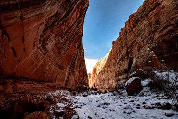Sun shining through The Narrows covered by snow at Capitol Reef National Park