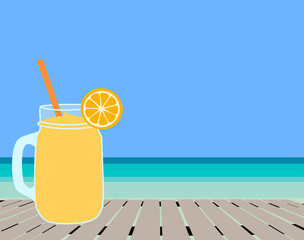 glass of orange smoothie juice on the beach