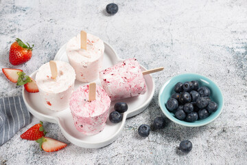Healthy summer desserts. Ice cream popsicles On white marble table