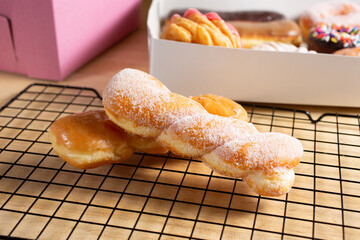 A view of a sugar coated and glazed twist donuts, in a still life setting.