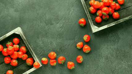 Fresh organic strawberry in vintage wooden box on green stone table. Healthy summer raw food concept.