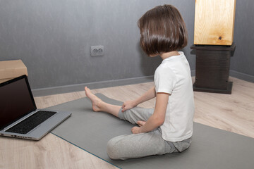 Kid doing fitness exercises at home in her room