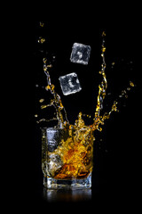Splashing of whiskey out of glass isolated on black