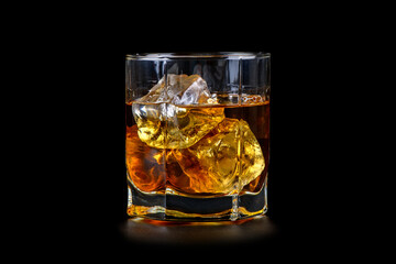 Glass of whiskey with cube ice on black background