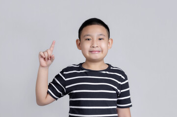 Portrait of happy Asian boy showing thumbs-up gesture.
