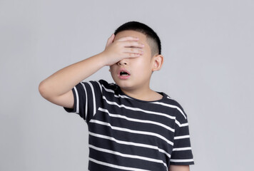 Asian boys studio portrait on gray background with hand on head for pain in head because stress. Suffering migraine.