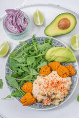 Vegan lunch bowl with quinoa, hummus, chickpeas, avocado
