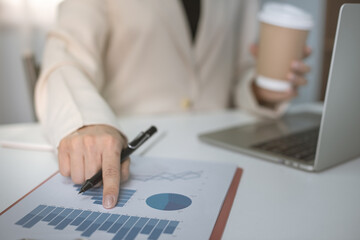 businesswoman working on desk and using laptop calculator and pad look very busy, work from home concept.