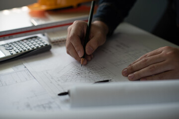 Architect working on blueprint. Architects workplace - architectural project, blueprints, ruler, calculator, laptop and divider compass. Construction concept. Blue print is fake only for stock photo.