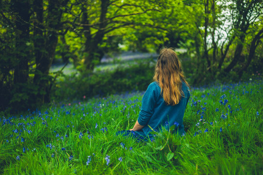 Young woman relaxing in meadow with bluebells