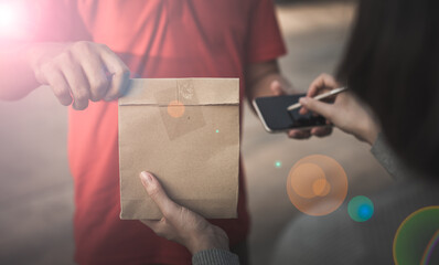 Deliver man wearing medical gloves and face mask in uniform handling bag and  parcel box give to female costumer Postman and express grocery delivery service during covid19.