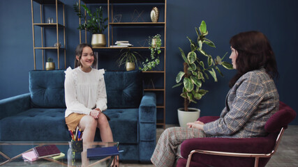 Smiling teenage girl listening to female doctor pediatrician school psychologist counselor talk to teen patient at checkup therapy consultation