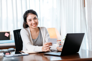 young woman hands holding credit card and using laptop for online shopping. Credit card buy or paymaent conceptl.