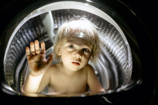 Happy child, sitting in thumble dryer, smiling