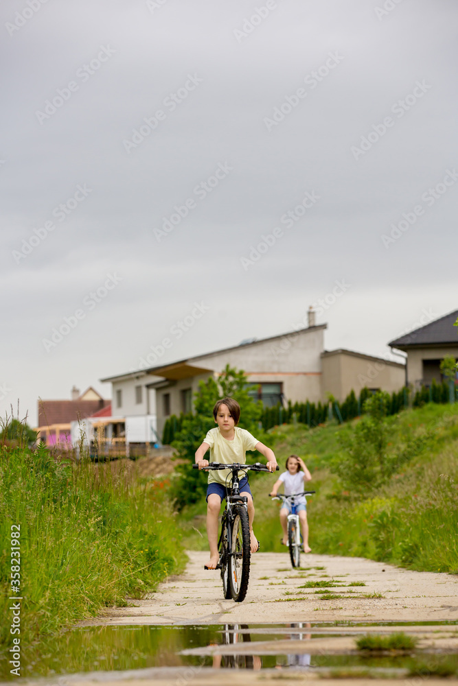 Poster Child, boy, riding bike in muddy puddle, summer time