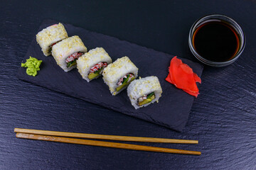 Uramaki sushi rolls with surimi on a black slate