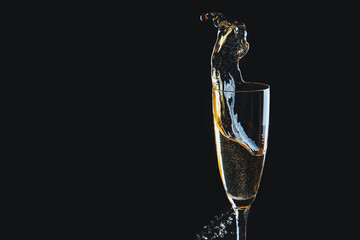 Glass of champagne with splash on dark background