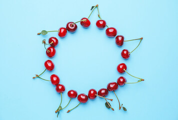 Frame made of sweet cherry on color background