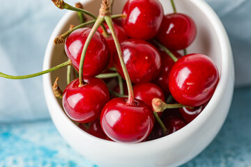 Bowl with sweet cherry on table, closeup