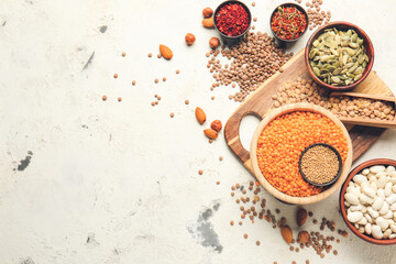 Different raw legumes and spices on white background