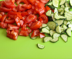 sliced cucumbers and tomatoes on a green background