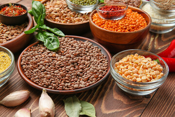Different raw legumes with spices on table