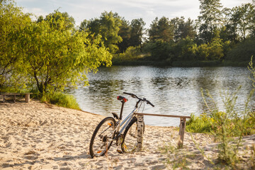 bike on the beach in sunset sunlight. bicycle riding. Sport lifestyle. Eco friendly transport. Bicycle Parked In beautiful nature place near tree. Camping Trip. Enjoying of freedom & nature on bicycle