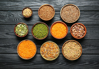 Bowls with raw legumes on table