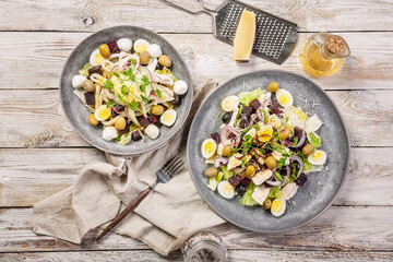 Top view squid salad with ice lettuce, sweet onions, sheeps spicy cheese, quail eggs, olives, micro-greens and olive oil. Mediterranean cuisine. Diet food. Copy space