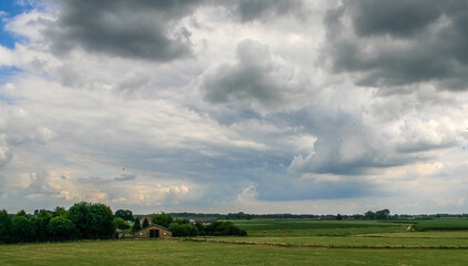 Fototapeta na wymiar dutch country side with heavy clouds on a warm summerday.