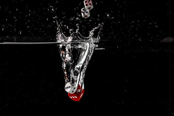 Ludo dice in water splash on black background with lots of air bubbles