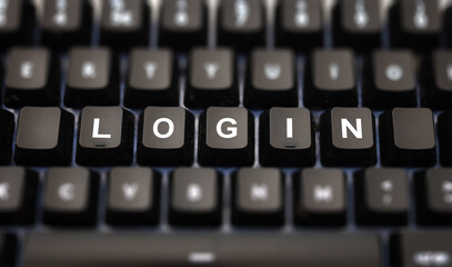 Login online concept. Login text written on keypad. Black keys with white letters message for identification and access on pc keyboard. Blur buttons background.