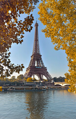 eiffel tower in paris between yellow foliage in autumn view from seine river