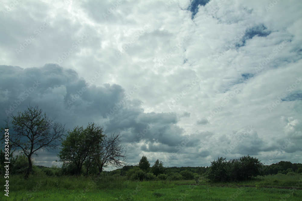 Canvas Prints thunderous epic clouds in a field near the old garden. stock photo background with heaven.