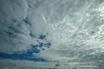 Picturesque clouds in the sky. Window view of an airplane on a sunny gloomy day. Stock photo background