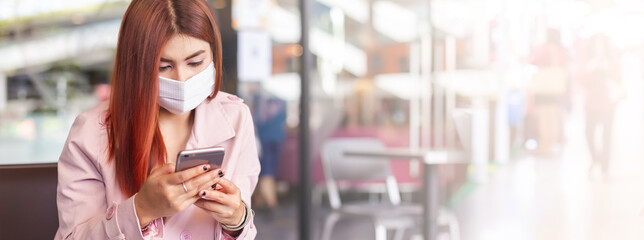 Asian woman wearing medical face mask for prevent dust and infection virus, using smartphone mobile phone in public, image banner size.