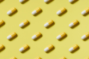 Pattern of yellow and white pills on a yellow background. Hard light. Paper background