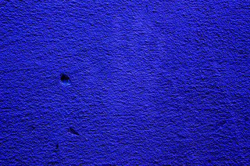 Blue colored abstract wall background with textures of different shades of blue and the imprint of...