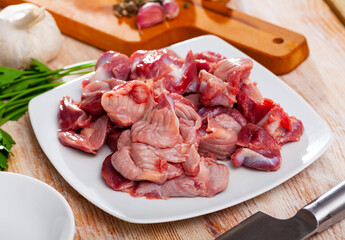 Raw chicken gizzards on wooden table