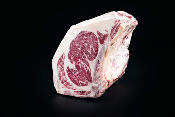 Raw dry aged wagyu cote de boeuf beef block as closeup on black background with copy space