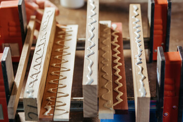 Bonding wood in the workshop. The use of glue for different types of wood. Making worktops for the kitchen. Work as a craftsman. Creating a cutting board design