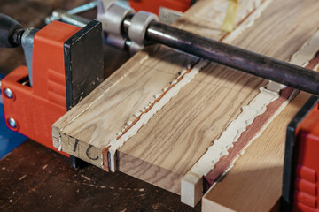 Bonding wood in the workshop. The use of glue for different types of wood. Making worktops for the kitchen. Work as a craftsman. Creating a cutting board design